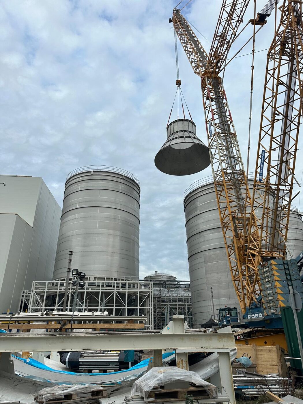 Stainless steel cone lifted between erected silos